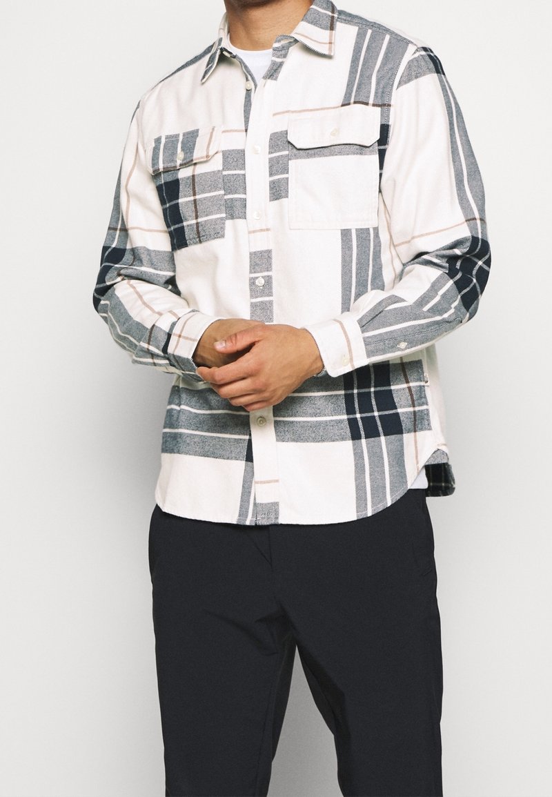 Camicia in flanella con base bianca e fantasia a quadri navy, grigia e rosa chiaro, colletto button-down e due tasche sul petto.