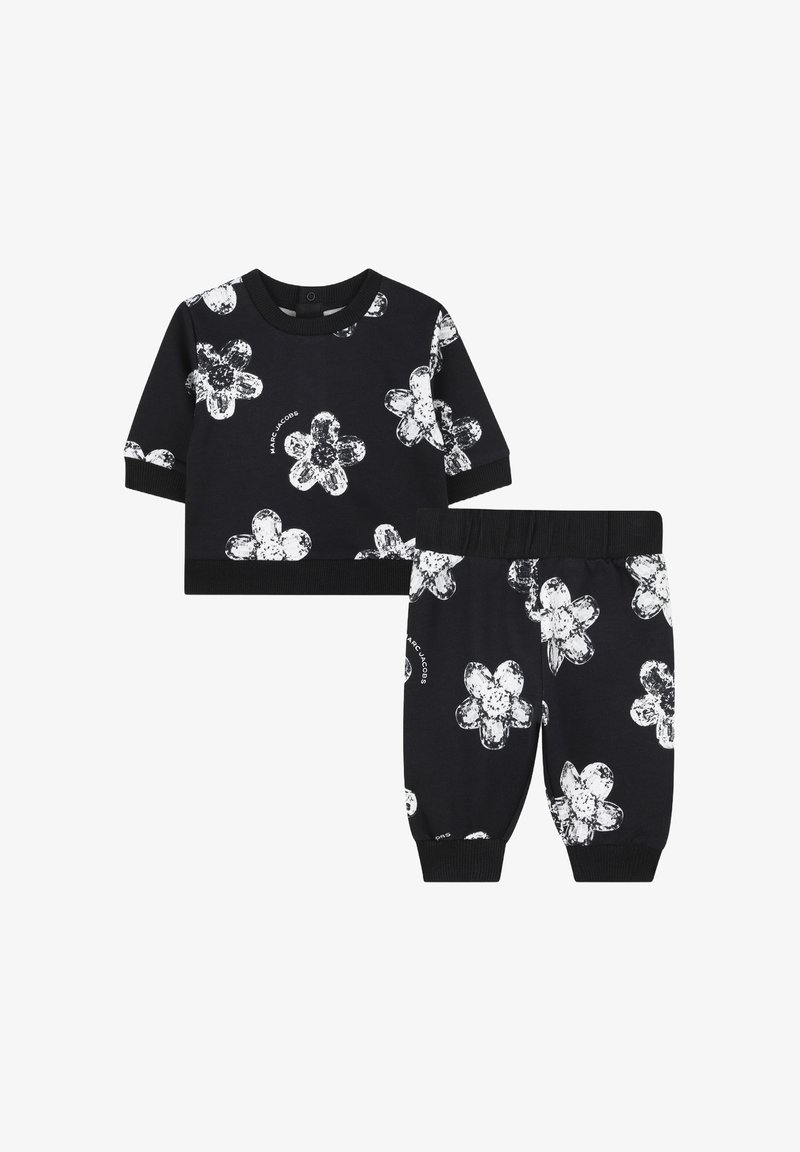 Ensemble en deux pièces en coton noir comprenant un haut à manches courtes et un pantalon à taille élastique, orné de motifs floraux blancs et de poignets côtelés.