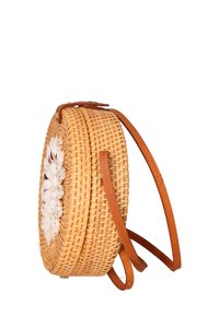 Borsa rotonda in paglia intrecciata con manici in pelle marrone; decorata con accenti di conchiglie bianche; presenta una texture liscia e un colore naturale.