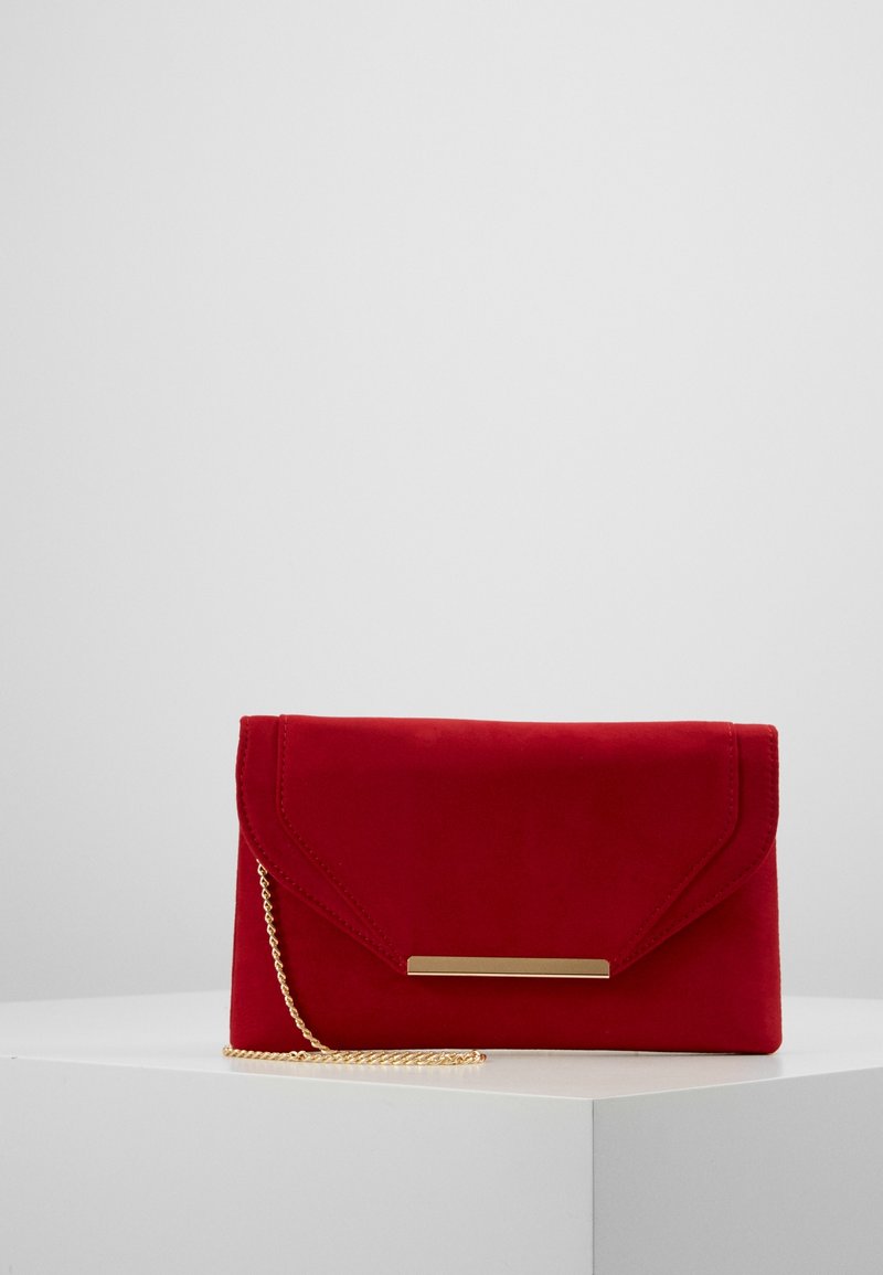 Pochette en daim rouge avec un accent en métal doré et une bandoulière chaîne. Présente un rabat à angle et une texture lisse.