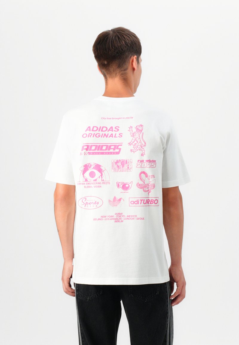 Hvit bomulls t-skjorte med rosa grafiske trykk på ryggen, inkludert logoer og tekst, med korte ermer og en avslappet passform.