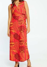 Robe longue rouge avec un design portefeuille, présentant un motif de feuilles tropicales vibrantes en orange et marron, tissu lisse, et accent noué sur le côté.