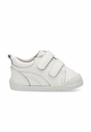 Zapatilla blanca de cuero con correas de velcro, punta redondeada, suela texturizada y un diseño de acento curvado en gris claro.