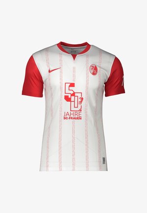 Maillot de football blanc avec manches rouges, fines rayures rouges et logo rouge 50 Jahre SC-Frauen à l'avant, avec un swoosh Nike rouge et un blason de l'équipe.