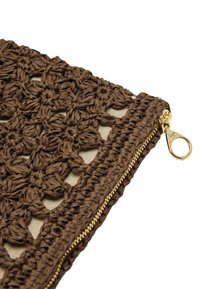 Brązowy szydełkowany woreczek o fakturowanym wzorze, ze złotym zamkiem błyskawicznym i beżowym podbiciem. Mierzy około 25 cm szerokości.