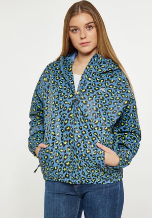 Blauwe luipaardprint jas met rits, elastische manchetten en zakken. Gemaakt van glanzend polyester met zwarte en neon groene vlekken.