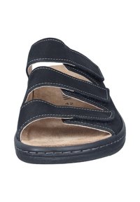 Schwarze Sandale mit drei verstellbaren Klettverschlüssen und gepolsterter Innensohle, ausgestattet mit weißen Nähten und einem konturierten Fußbett für Komfort.