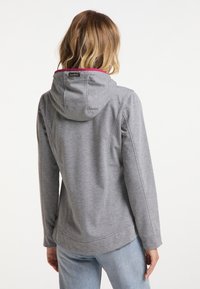 Sweat-shirt gris à capuche, avec une doublure intérieure rose, un tissu texturé et des coutures plates. Le design comprend une petite étiquette logo à l'arrière.