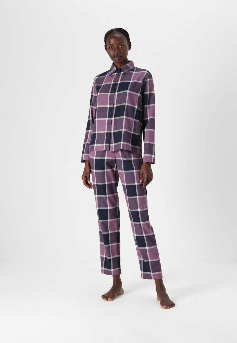 Geruite flanellen pyjamapakket in paarse, marineblauwe en witte tinten. Bevat een overhemd met kraag en knopen en rechte broekspijpen.