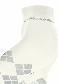 Calzini bianchi con un motivo testurizzato di quadrati grigi e una fascia decorativa in alto. Il materiale sembra liscio con una leggera lucentezza.
