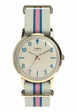 Timex Marlin óra arany tokban, krémszínű számlappal, kék számokkal, rózsaszín másodpercmutatóval és szürke szövet szíjjal, rózsaszín és kék csíkokkal.