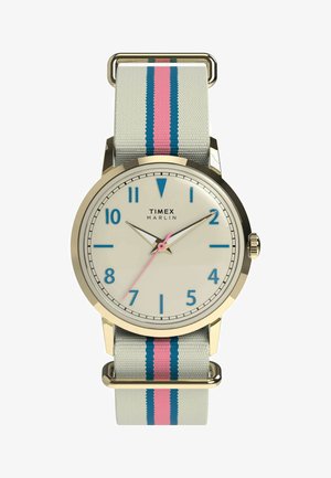 Hodinky Timex Marlin so zlatým puzdrom, krémovým ciferníkom, modrými číslicami, ružovou sekundovou ručičkou a sivým textilným remienkom s ružovými a modrými pruhmi.