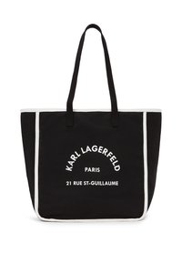 Sac fourre-tout noir en toile avec des accents blancs, portant le texte imprimé : "Karl Lagerfeld Paris 21 Rue St-Guillaume." Deux poignées robustes.