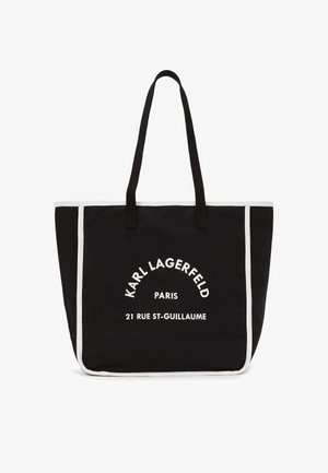 Musta kanvas kantoreppu valkoisilla yksityiskohdilla, jossa on printattu teksti: "Karl Lagerfeld Paris 21 Rue St-Guillaume." Kaksi tukevää kahvaa.