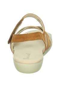 Beige Wildledersandalen mit zwei verstellbaren Riemen und einer hellen Gummisohle. Die Rückansicht zeigt ein minimalistisches Design und strukturierte Lederelemente.