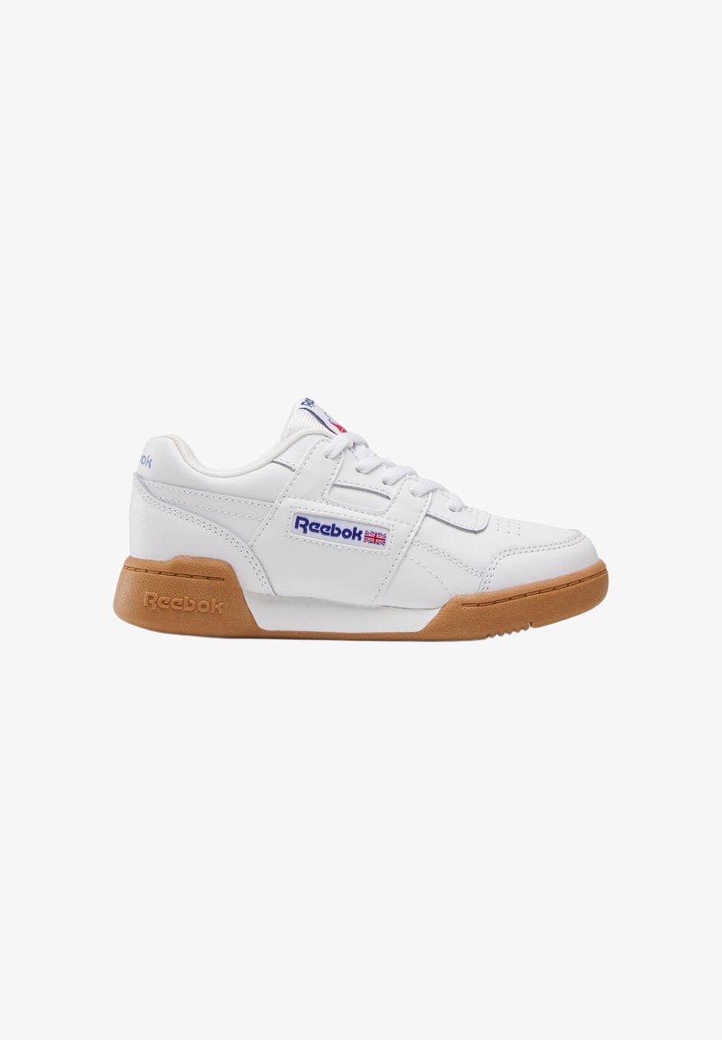 Baskets basses blanches Reebok avec semelle marron, laçage à l'avant et logo bleu avec drapeau britannique sur le panneau latéral.