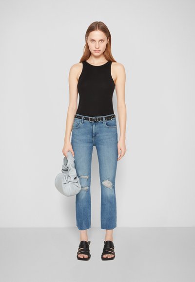 Bodysuit sem mangas preto, jeans claros rasgados azuis, cinto preto com tachas prateadas, bolsa cinza em camadas e sandálias deslizantes pretas.