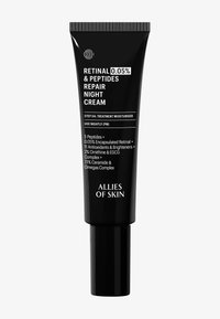 Tube en plastique noir avec un capuchon à vis. Présente un texte blanc pour le nom du produit et les instructions. Contient des ingrédients pour les soins de la peau énoncés sur l'étiquette.
