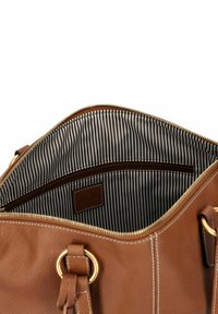 Braune Lederhandtasche mit goldenen Beschlägen, ausgestattet mit einem gestreiften schwarz-weißen Innenfutter und einer Reißverschlusstasche. Außen mit aufgesteppten Details.