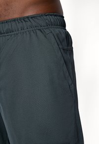 Donkergrijze sportshorts van gestructureerde stof, met een elastische tailleband en zijzakken.