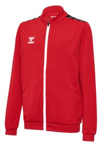 Veste rouge à fermeture éclair avec un col montant, une fermeture éclair blanche, un tissu texturé et des accents noirs sur les épaules. Comprend des poches latérales.