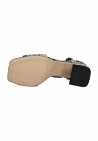 Sandalo con tacco dalla stampa serpente bianco e nero. Presenta una suola beige e un tacco in gomma nera, con una texture liscia e una fibbia regolabile.