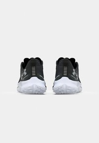 Zapatos deportivos negros con parte superior texturizada, suela blanca y banda de rodadura de goma transparente, con un logotipo en el talón y acentos verticales.