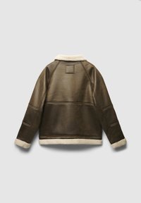 Brązowa kurtka z sztucznej skóry z kremowym kołnierzem i mankietami z owczej wełny. Posiada kwadratową naszywkę na górnej części pleców i poziome detale przeszycia.