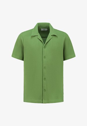 Trumpas rankovėmis marškiniai iš tekstūruoto šviesiai žalios medžiagos, su mygtukų užsegimu priekyje ir smailiu apykakle. Vaflinio rašto dizainas prideda vizualinio susidomėjimo.