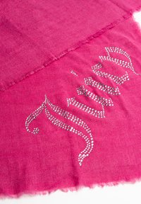 Sciarpa fucsia con una texture morbida, caratterizzata da un design decorativo di cristalli argentati che formano motivi sinuosi lungo un bordo.