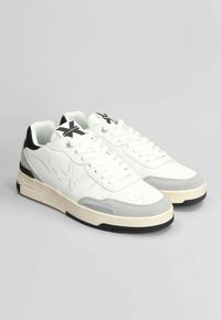 Sneaker bianche con accenti grigi e neri, materiali in pelle e camoscio, design perforato, punta rotonda e suola piatta in gomma.