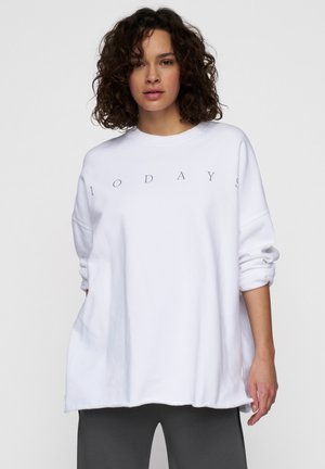 Sudadera oversized blanca con mangas enrolladas que presenta el texto gráfico "1 0 D A Y S" en gris. Material suave y un corte relajado, con un escote redondeado.