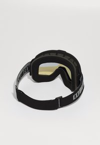 Zwarte skibril met een gele lens, schuimrubberen padding en een brede verstelbare band met logo-details. Gladde oppervlaktextuur.