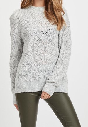 Maglione grigio chiaro a maglia con un motivo a foglie testurizzato, colletto rotondo e maniche lunghe, abbinato a pantaloni aderenti verde oliva.