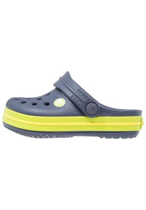 Sabot Crocs bleu marine avec des bandes vert citron sur la semelle et des trous de ventilation, avec une bride arrière et le logo Crocs sur le côté.