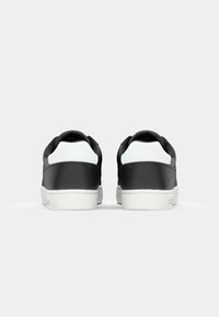 Zwarte leren sneakers met witte accenten en een getextureerde zool. Heeft een gladde afwerking en een ronde hak, ontworpen voor casual gebruik.