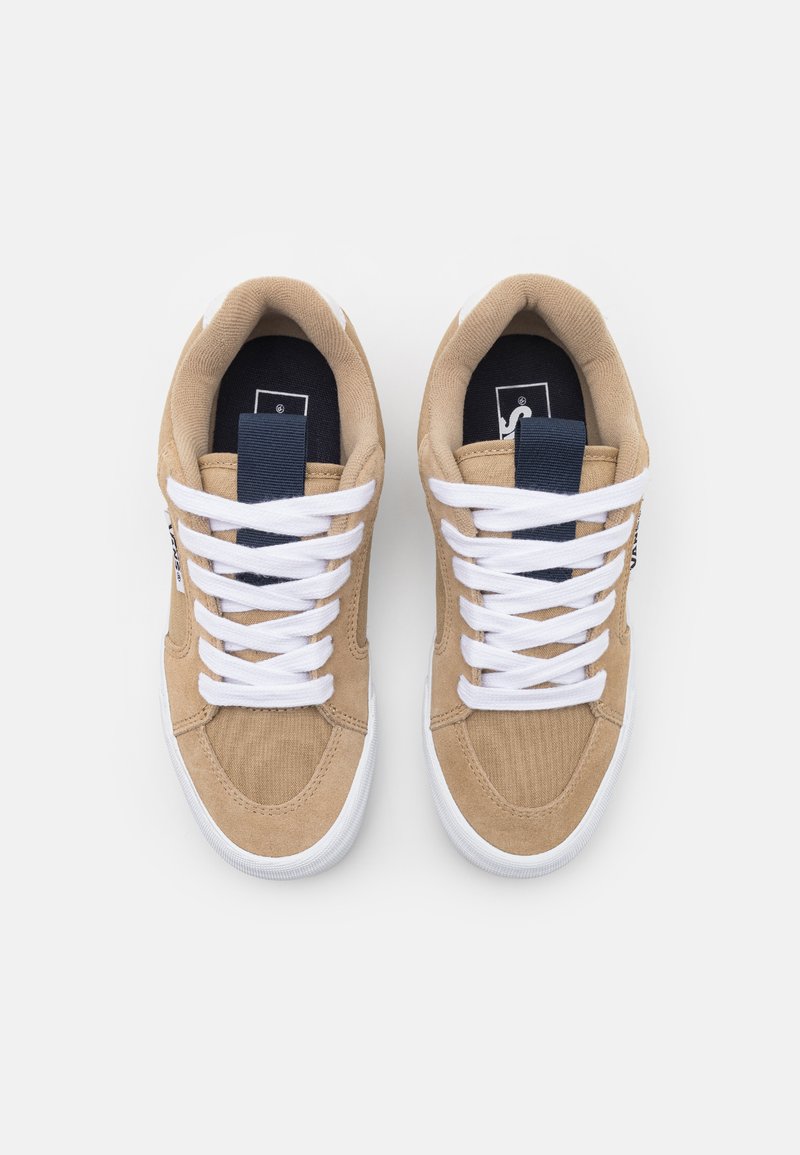 Beżowe zamszowe sneakersy z białymi sznurówkami, granatowym akcentem na języku, teksturowaną cholewką oraz białą gumową podeszwą. Zaprojektowane do codziennego noszenia.