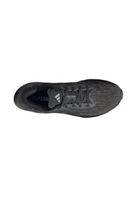 Chaussure de course noire avec une tige en maille texturée, lacets plats et semelle rembourrée. Logo visible sur la semelle intérieure. Design léger.