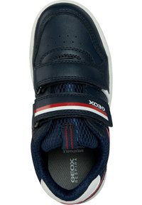 Baskets en cuir bleu marine avec bande Velcro, semelle blanche, accents rouges et blancs, et doublure en mesh respirant. Marque Geox sur la bande.