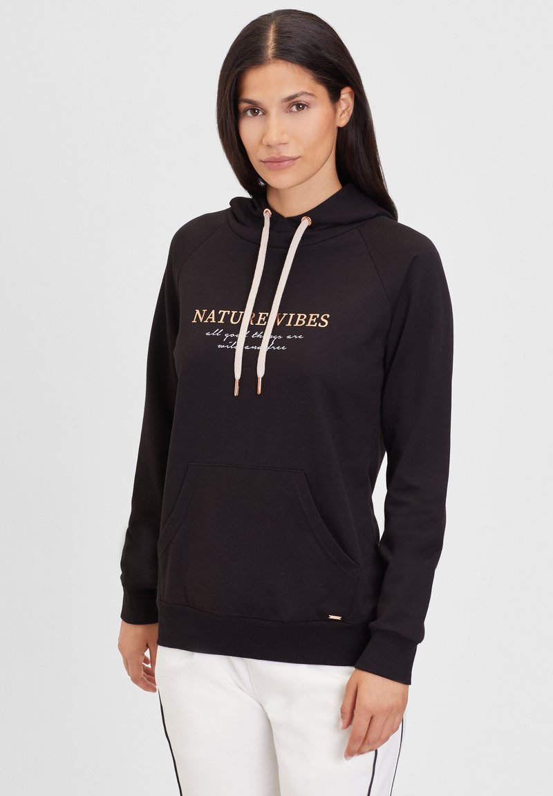 Sudadera con capucha negra hecha de tela suave, que presenta un gráfico en dorado que dice "NATURE VIBES", con un bolsillo tipo canguro y detalles de cordón.