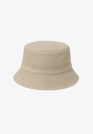 Beżowy kapelusz typu bucket wykonany z bawełnianej tkaniny. Cylindryczny kształt z płaskim wierzchołkiem i szerokim, zakrzywionym rondem o poziomej, prążkowanej teksturze.