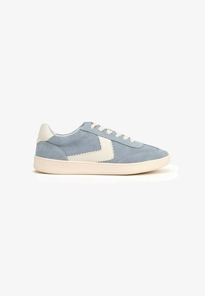 Sneaker in suede azzurro chiaro con suola in gomma crema, lacci crema e un accento bianco scallopato sul lato. Design atletico classico.
