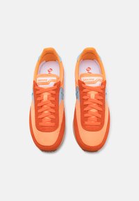 Orange running shoes with a combination of smooth and suede materials. Light blue accents and textured rubber soles, featuring six orange laces.