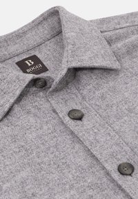 Grijze wollen shirt met een gestructureerde afwerking, voorzien van een klassieke kraag, twee zwarte knopen en een logo-label met "Boggi Milano."