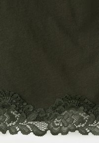 Tissu vert foncé avec une bordure en dentelle florale complexe le long du bord, montrant une texture de maille fine et des détails délicats du motif.