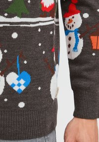 Mörkbrun stickad tröja med färgglada snögubbar och hjärtmönster. Har röda detaljer, snöflingeapplikationer och ribbade mudd för textur.