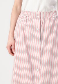Riba skirt valges koos punaste ja siniste triipudega, millel on elastne vöökoht, nupuvajutus ja kerge kangastekstuuri.