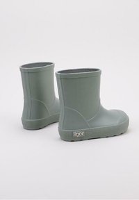 Botas de lluvia de goma verdes con una suela texturizada y punta redondeada. Caño corto con un acabado suave y etiqueta de logo en el costado.