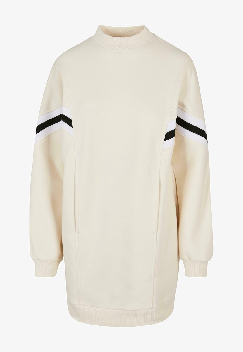 Robe-sweatshirt longue couleur crème avec col montant côtelé, poignets et ourlet, et rayures chevrons noir et blanc sur le haut des manches.