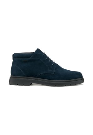 Botas chukka de ante azul marino con punta redonda, diseño con cordones y suela de goma negra con un patrón de textura.